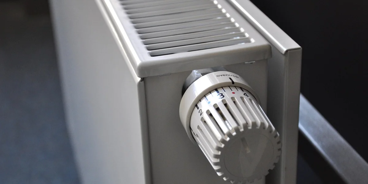 Close-up of a temperature control knob on a metal enclosure heater