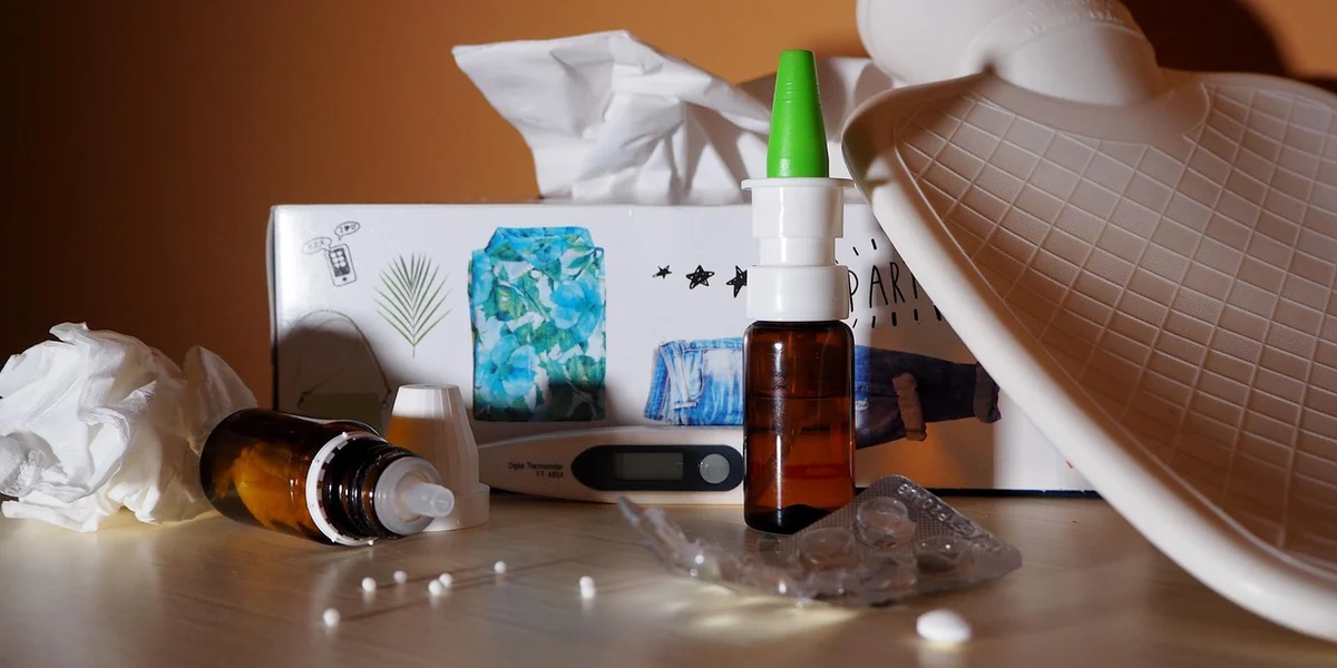 A desk setup with hydration supplies (dropper bottles, a spray bottle, tissues, and packaging) arranged for mantis care.