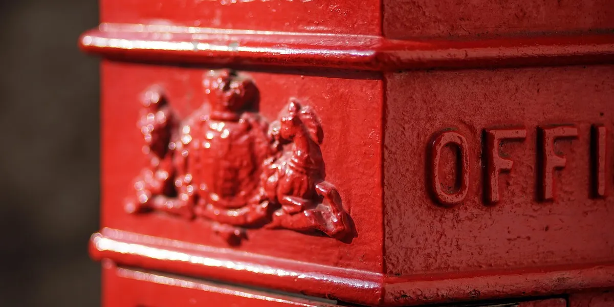 Close-up of a red mailbox with embossed figures, symbolizing secure mailing.