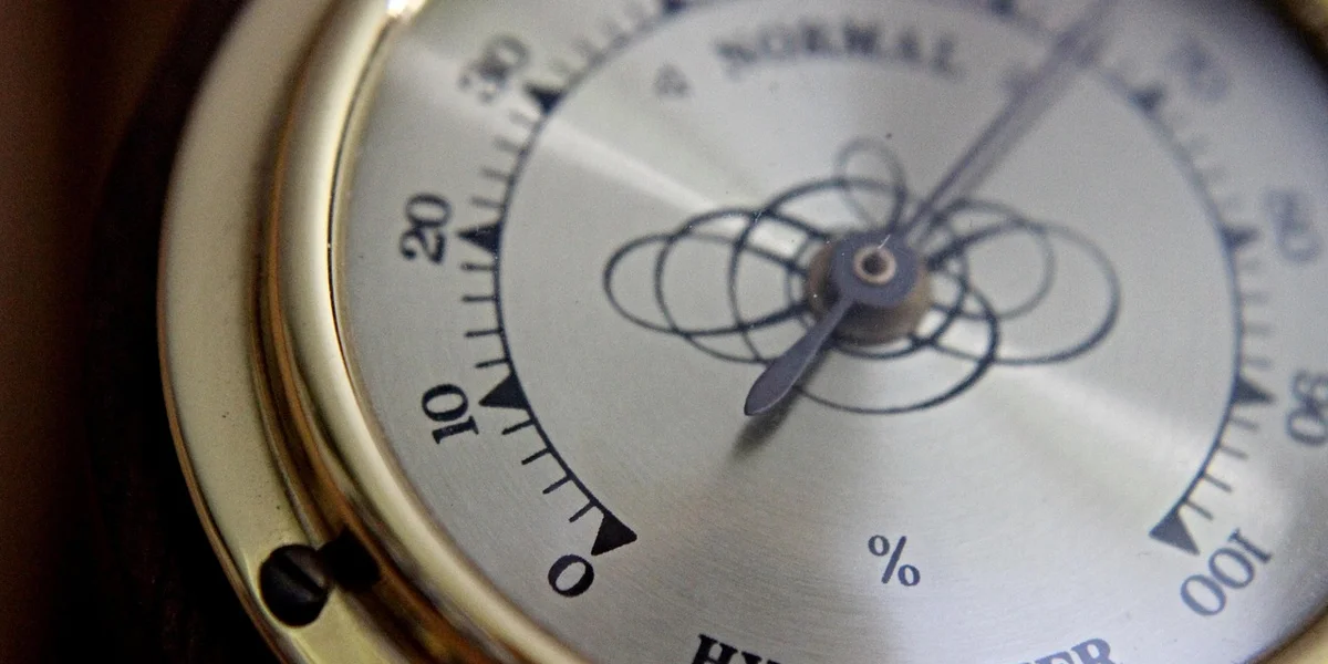 Close-up of a circular hygrometer dial with percent humidity markings
